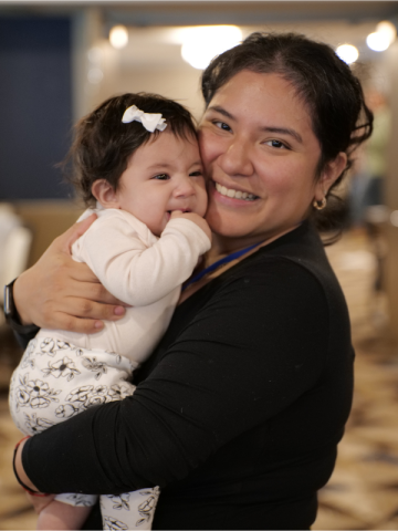 Mom leader holding her baby at a MomsRising bootcamp