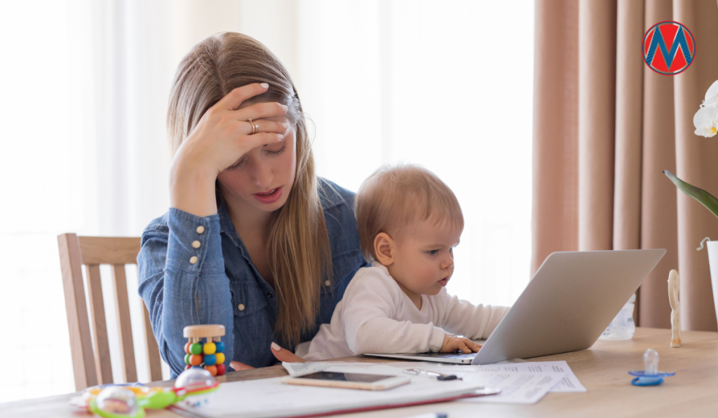 A stressed out mom with blond hair hold her baby in front of a stack of bills